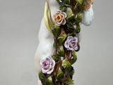 a figurine of a cat with flowers on it ' s head