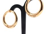 pair of black and gold hoop earrings on a black stand