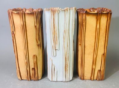 trois vases posés côte à côte sur une table