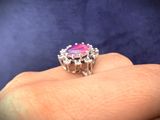 a close up of a person ' s hand holding a pink and white ring