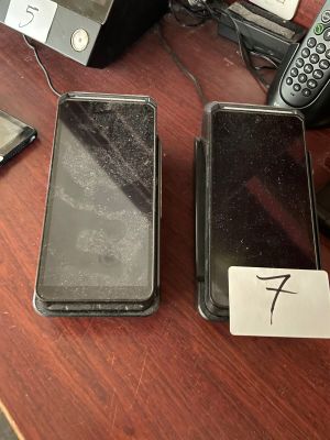 two cell phones sitting on a table next to each other