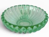 un bol en verre vert posé sur une surface blanche