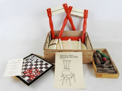 une chaise en bois aux pieds rouges et un échiquier dans une boîte