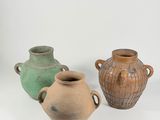 three vases sitting next to each other on a white surface