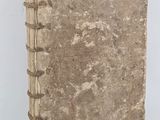 an old book is sitting on a table with a white background