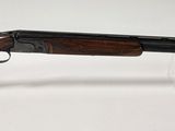 un pistolet avec une crosse en bois et un étui en plastique transparent