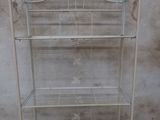 a white metal shelf with a bird cage on top of it