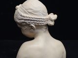white sculpture of a woman with braids on her head