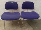 deux chaises violettes placées l'une à côté de l'autre devant un mur blanc