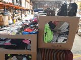 two boxes of clothes and a pair of shoes in a warehouse