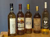 plusieurs bouteilles de vin sont alignées sur un plateau en bois