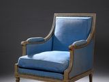 un fauteuil rembourré bleu dans une pièce sombre, sur fond noir