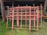 an image of a pile of old red metal bars sitting in the grass