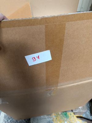 une personne tenant un carton sur lequel est collé un autocollant