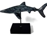 statue of a shark on a black base on a white background