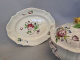 two plates and a bowl with flowers on them on a table