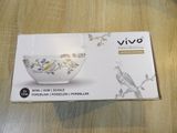 packaging of a boxed bowl on a wooden table with a bird on it