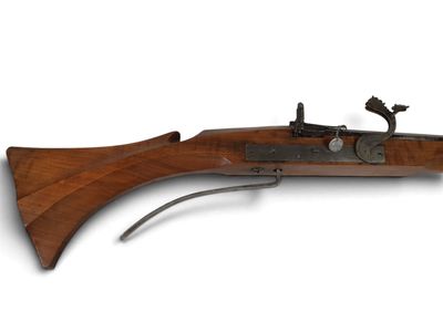 un vieux fusil avec un canon en bois et une poignée en métal