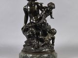 a bronze statue of a woman holding a child on a marble base