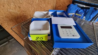 a calculator sitting on a wire shelf next to a blue box