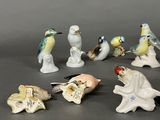 many figurines of birds that are sitting on a table