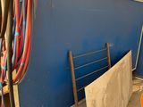 a blue wall with a bunch of hoses on top of it