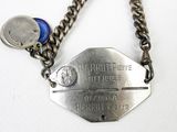a silver chain with a blue button attached to it