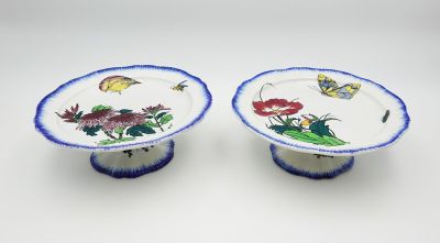 une paire d'assiettes bleues et blanches ornées de fleurs et de papillons