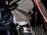 a close up of a motorcycle engine with a red hose attached to it