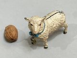 a figurine of a sheep and a walnut on a table