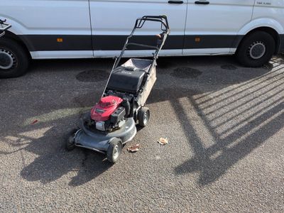 a lawn mower that is sitting in the parking lot