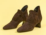 une paire de bottines en daim marron sur fond jaune