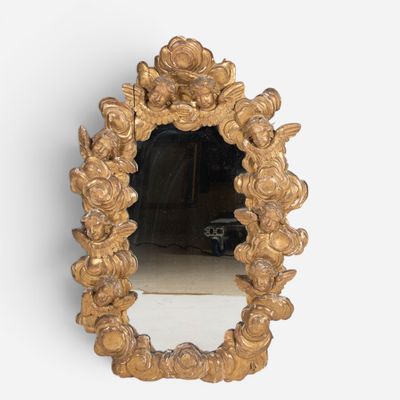 a mirror that has a gold frame with flowers on it