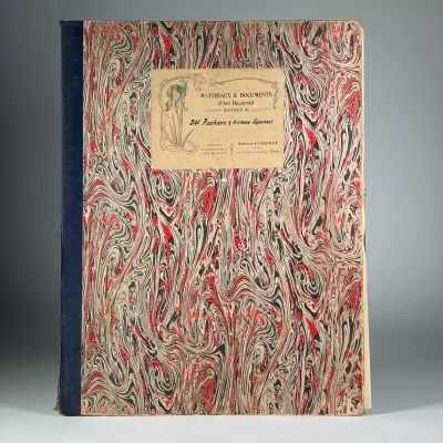 un vieux livre à la couverture rouge et bleue posé sur une table