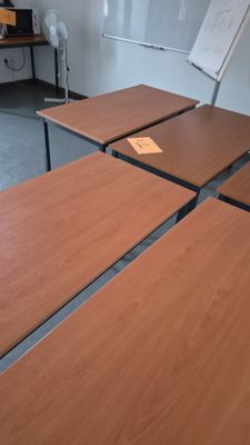 quatre tables en bois dans une pièce aux murs blancs