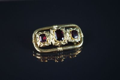 une image représentant une bague en or sertie de grenats
