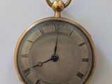 une montre de poche en or avec des chiffres romains sur le cadran