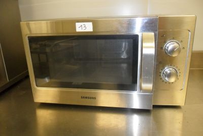 a silver microwave sitting on a counter in a kitchen