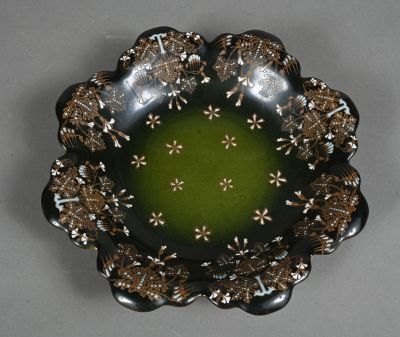 a black plate with a green center surrounded by brown and white flowers
