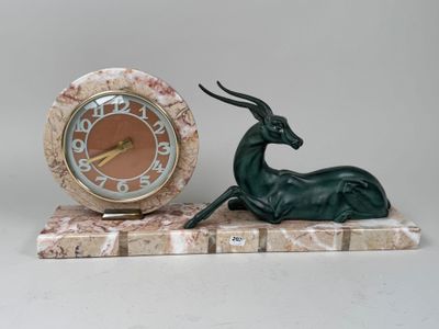 une statue d'antilope et une horloge posées sur un socle en marbre