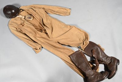 un uniforme marron, avec un casque et des bottes, posé sur une surface blanche
