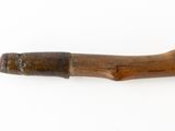 an old wooden pipe with a wooden handle on a white surface