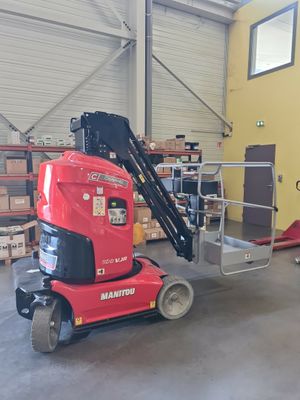 a red scissor sitting in a warehouse with boxes on the floor