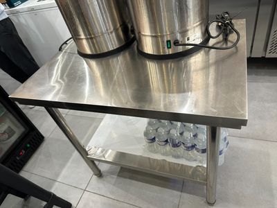 une table en acier inoxydable sur laquelle sont posés deux seaux