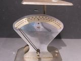 une balance métallique sur laquelle est posée une horloge, posée sur une table