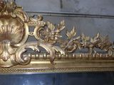 a mirror with a gold decoration on it in a room