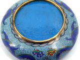 a blue vase with a gold rim sitting on a white surface
