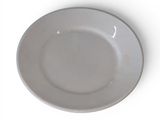 une assiette blanche posée sur une table blanche, avec une fourchette et un couteau
