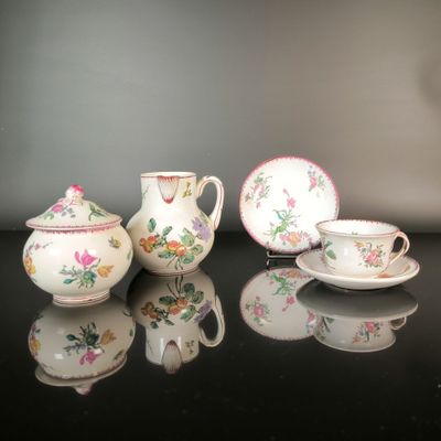 three teapots and two cups sitting on a table