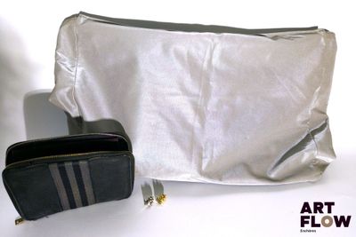 un sac argenté et un sac noir posés sur une table blanche